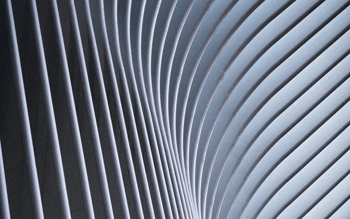 Curved white architectural ribs creating a rhythmic pattern of light and shadow
